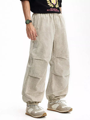 Khaki relaxed fit cargo pants with elastic waistband and cuffs, featuring paneled legs.