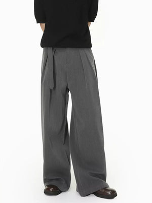 Grey wide-leg pleated sweatpants with a belted waist.