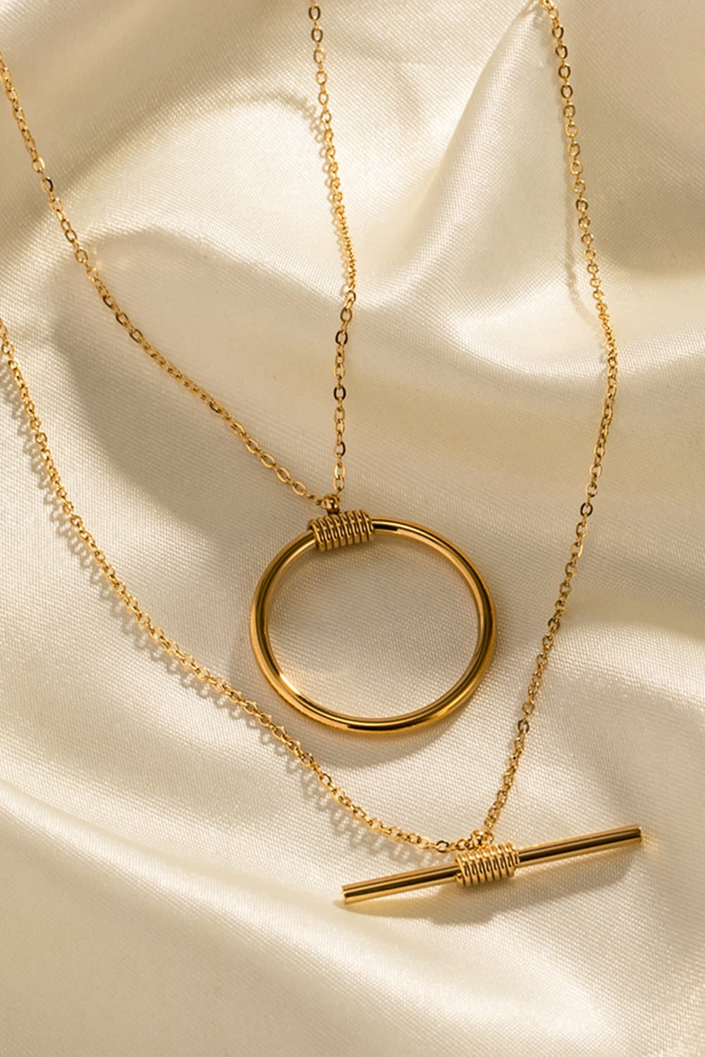Double-layered gold necklace with circle and bar pendants, 18K gold-plated.
