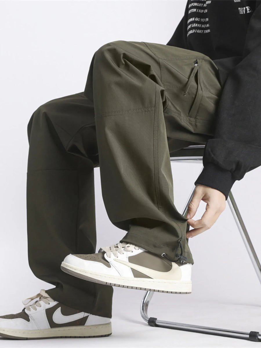 Relaxed fit green cargo pants with zip pockets and adjustable ankle cuffs.