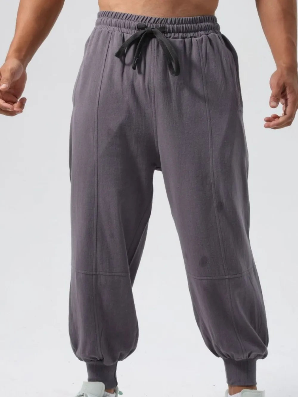 Relaxed fit dark gray joggers with seam details and adjustable drawstring waist.