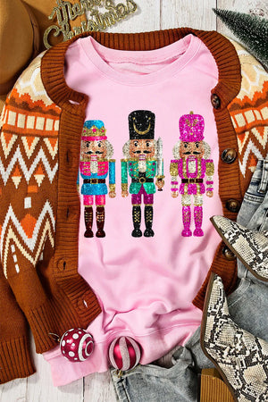 Blush pink crewneck sweatshirt with a graphic of three colorful nutcrackers.