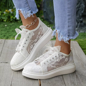 White sneakers featuring round toe and lace