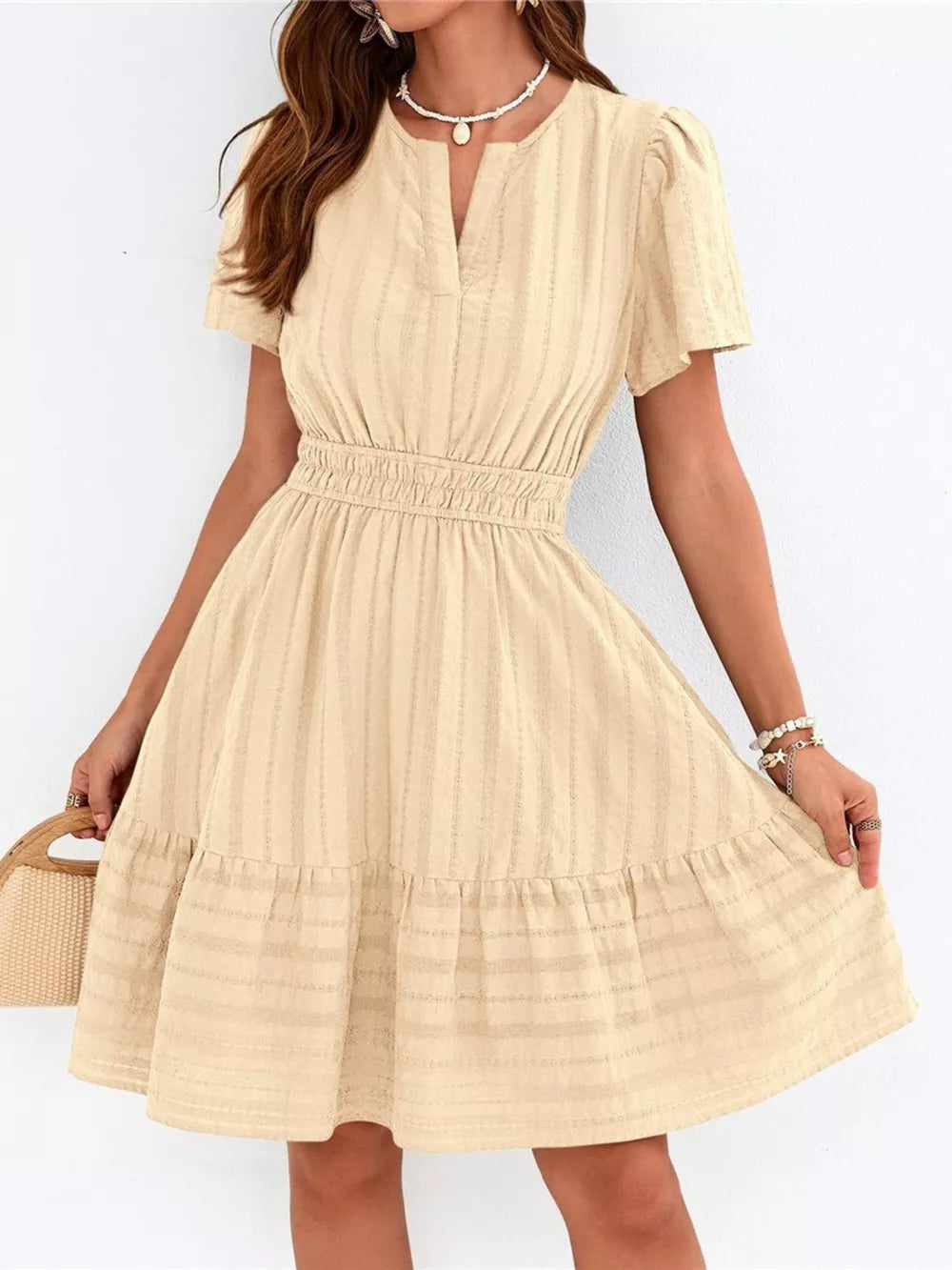Apricot textured V-neck tiered dress with smocked waist and short puff sleeves.