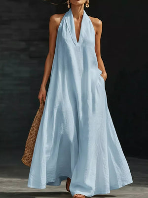 Light blue polyester halter neck maxi dress with pockets and deep V-neck.