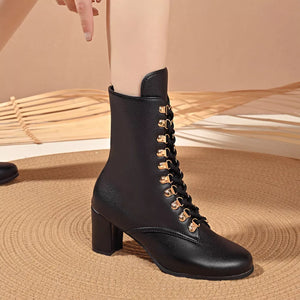 Black leather lace-up block heel boots with gold eyelets.