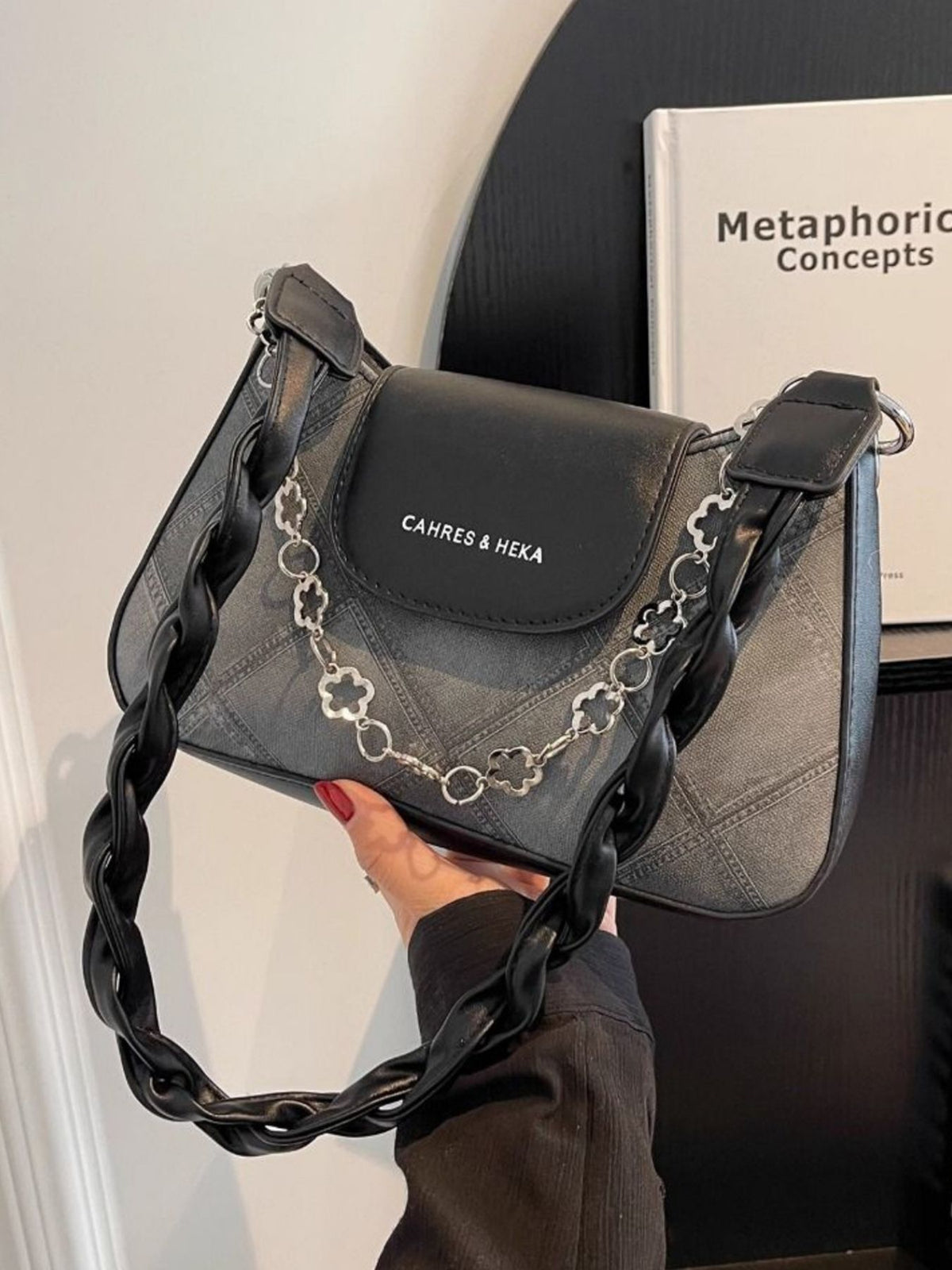 Textured black shoulder bag with chain strap and braided strap detail