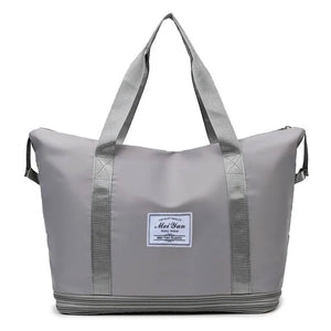 Gray expandable travel tote bag with contrast trim and zipper detail.