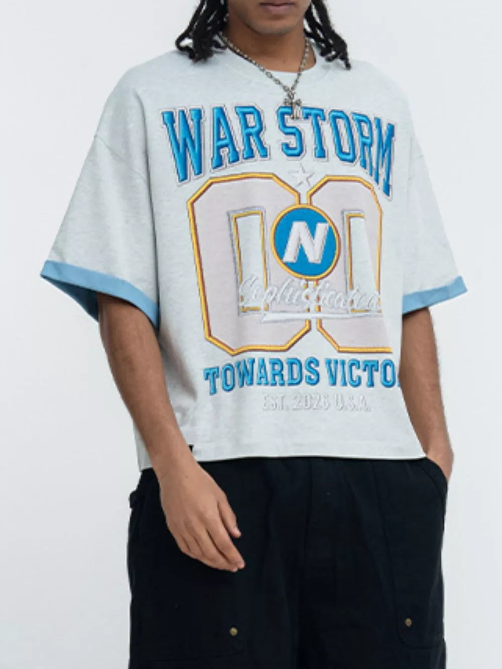 Light grey graphic t-shirt with blue trim sleeves and "WAR STORM" text.