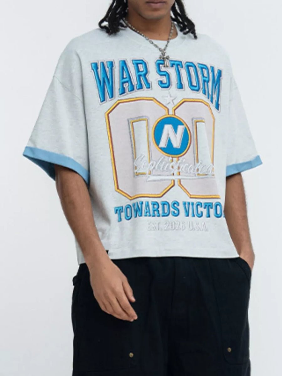 Light grey graphic t-shirt with blue trim sleeves and "WAR STORM" text.