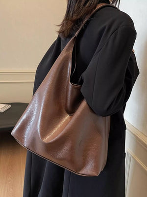 Brown PU leather tote bag with slouchy silhouette and single strap.