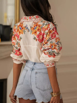 Embroidered floral print button-up shirt with rolled sleeves and light wash denim shorts with scalloped hem.
