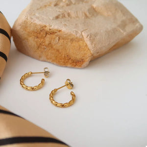 Elegant twisted gold hoop earrings, 18K gold-plated alloy, with stud backs.
