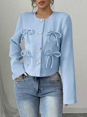 Light blue textured jacket with round neck, long sleeves, gold button closure and decorative bows.