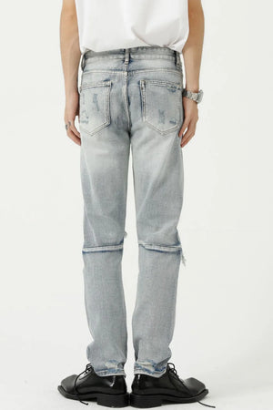 Light wash ripped knee slim fit denim jeans with distressed details and a raw hem.