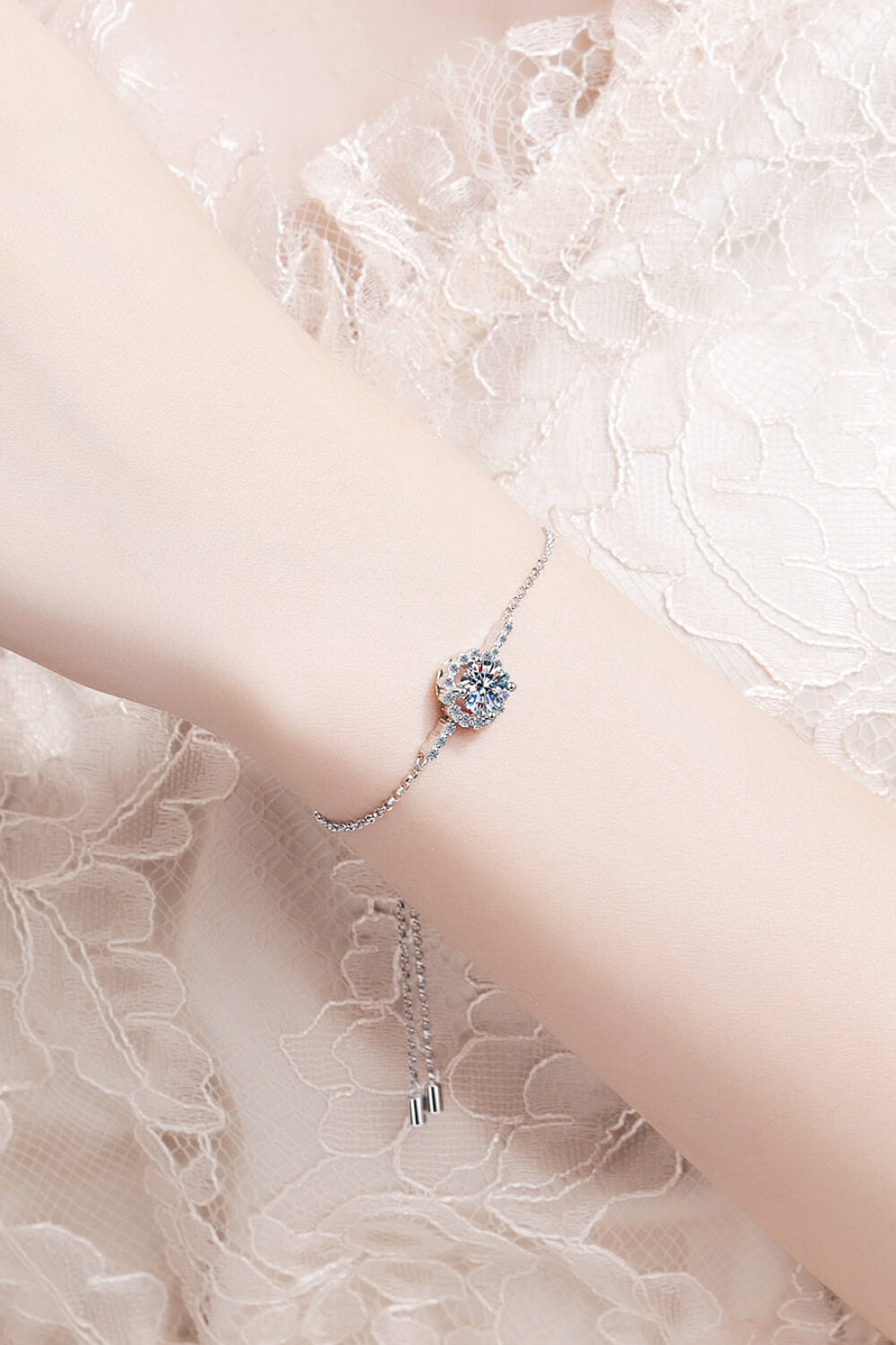 Silver adjustable bracelet with a sparkling floral-shaped cubic zirconia center stone.