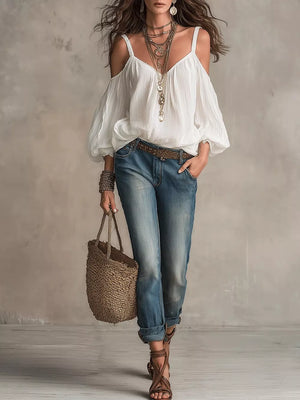 White cold shoulder balloon sleeve shirt with spaghetti straps and V-neck, styled with jeans and sandals.