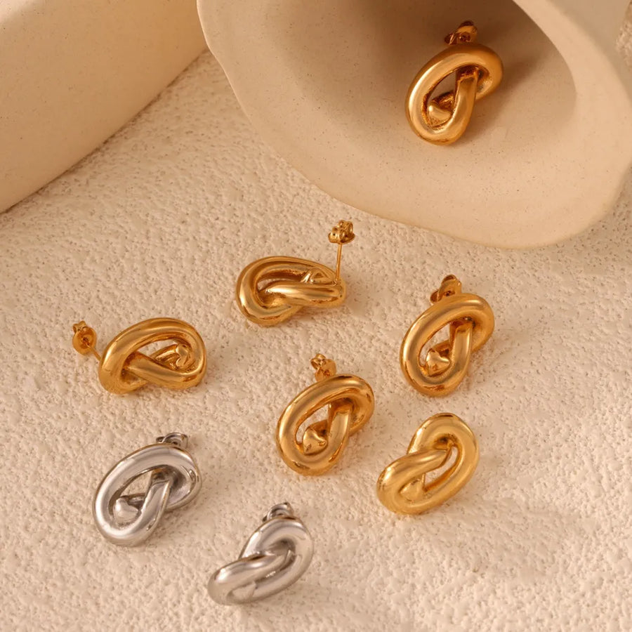 Sculptural knot stud earrings in gold and silver, artistic and chic accessories.