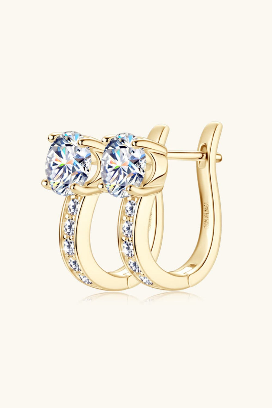 Gold pavé and solitaire hoop earrings with oval-cut stones and channel-set accents.