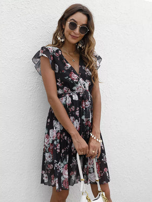 Black floral pleated dress with ruffle sleeves and a belted waist.