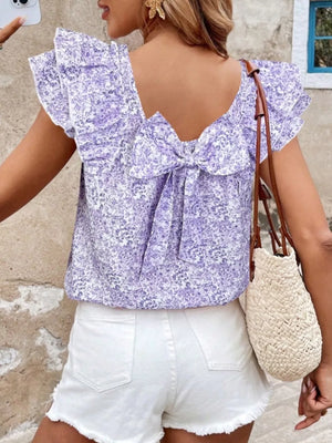Purple floral ruffle blouse with back bow detail and short sleeves.