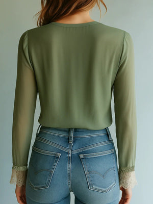 Olive green blouse with sheer bishop sleeves and lace cuffs, paired with blue jeans.