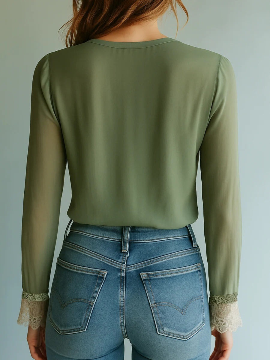 Olive green blouse with sheer bishop sleeves and lace cuffs, paired with blue jeans.
