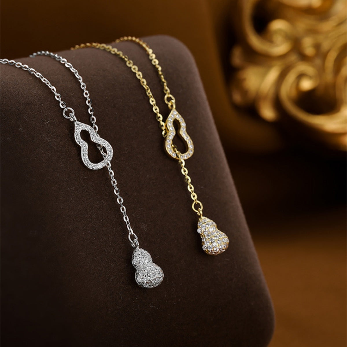 Silver and gold zircon pendant necklaces with double gourd charm.