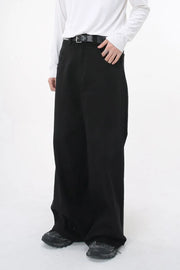 Black wide-leg denim jeans with sculpted volume and a belt, styled casually.