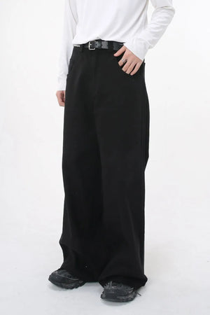 Black wide-leg denim jeans with sculpted volume and a belt, styled casually.