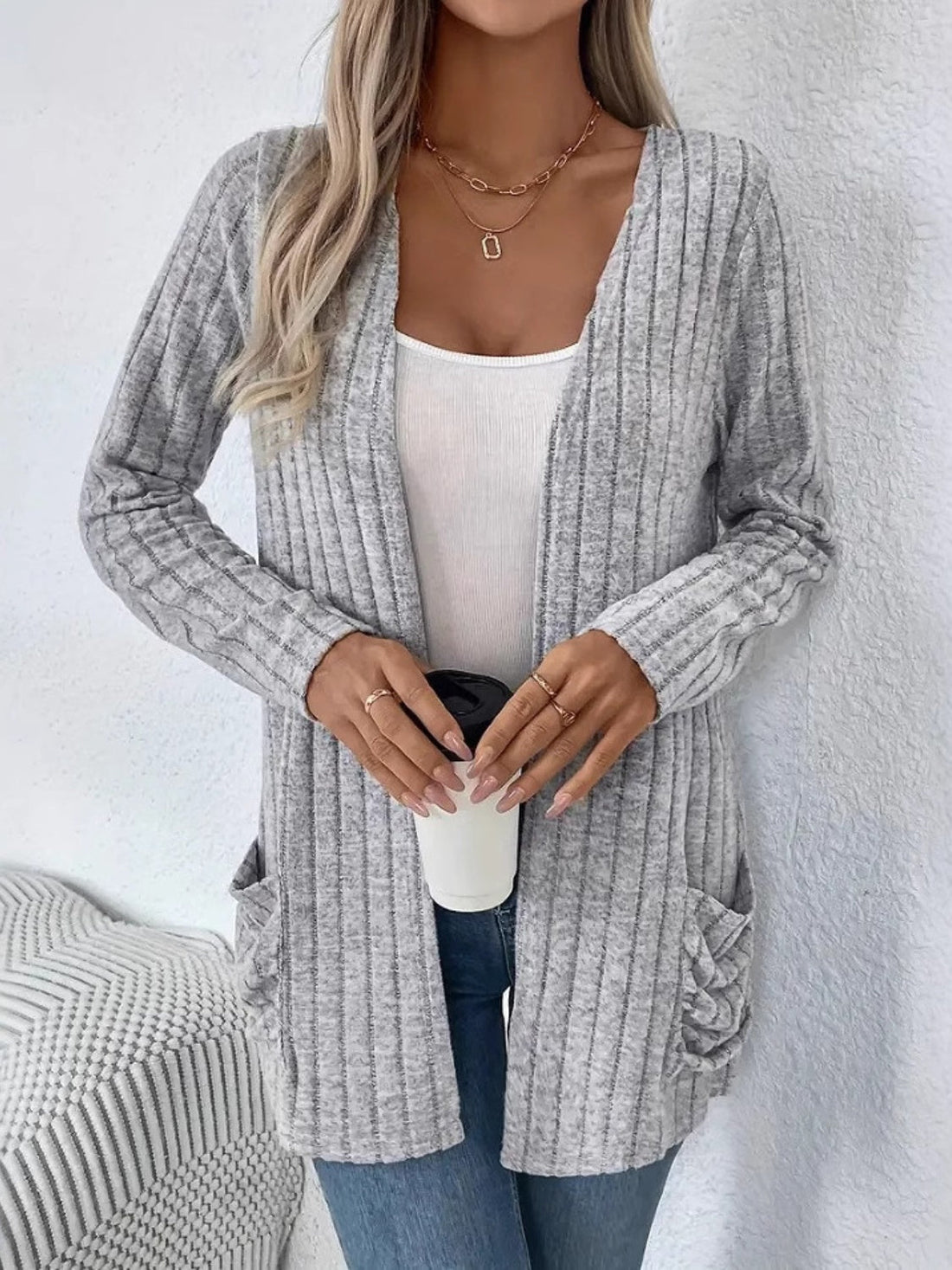 Light gray ribbed knit cardigan with drape front and pockets, worn open over a white tank top.
