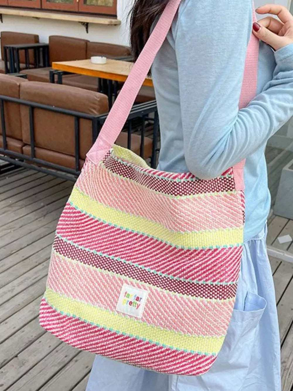 Vibrant striped woven shoulder bag with pink strap and a small "far far pretty" label.