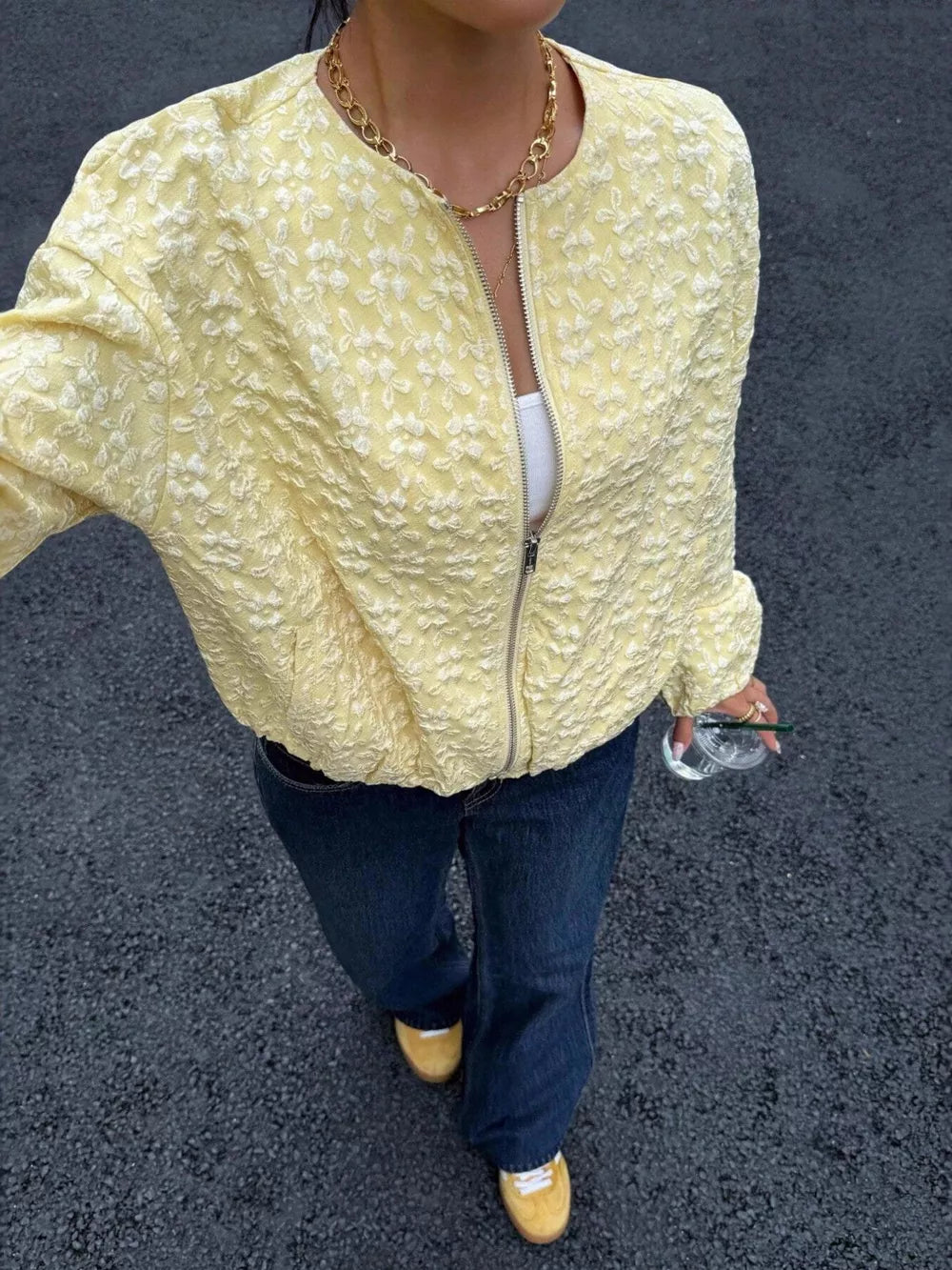 Yellow textured floral embossed zip bomber jacket with a collarless neckline.