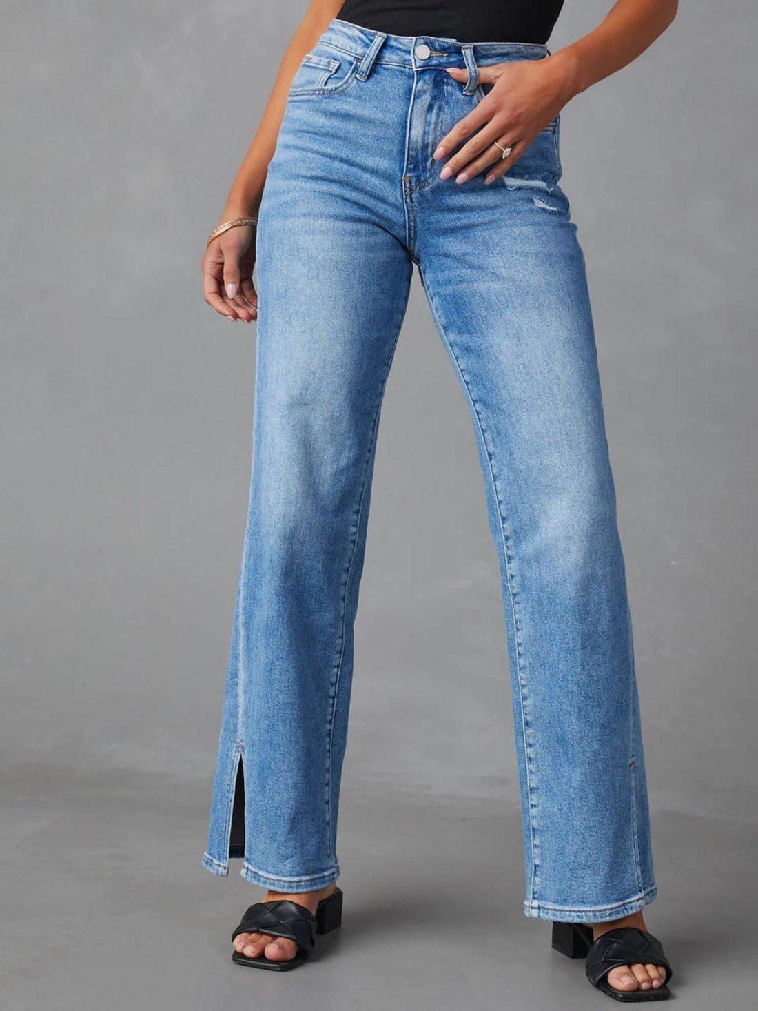 Medium wash split hem flare jeans with a button fly and distressed detail.