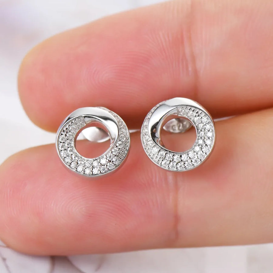 Silver pavé circle stud earrings with delicate, sparkling stones.