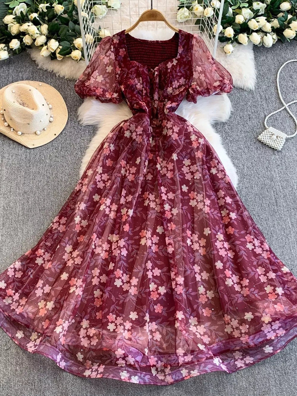 Crimson floral maxi dress with sweetheart neckline, puff sleeves, and sheer overlay.