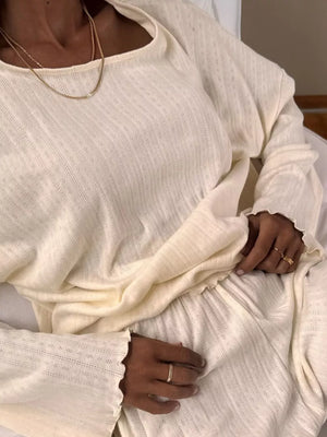 Cream ribbed knit lounge set with textured pattern and ruffled cuffs.