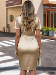 Champagne satin ruched wrap dress with sheer polka dot sleeves and a fitted skirt.