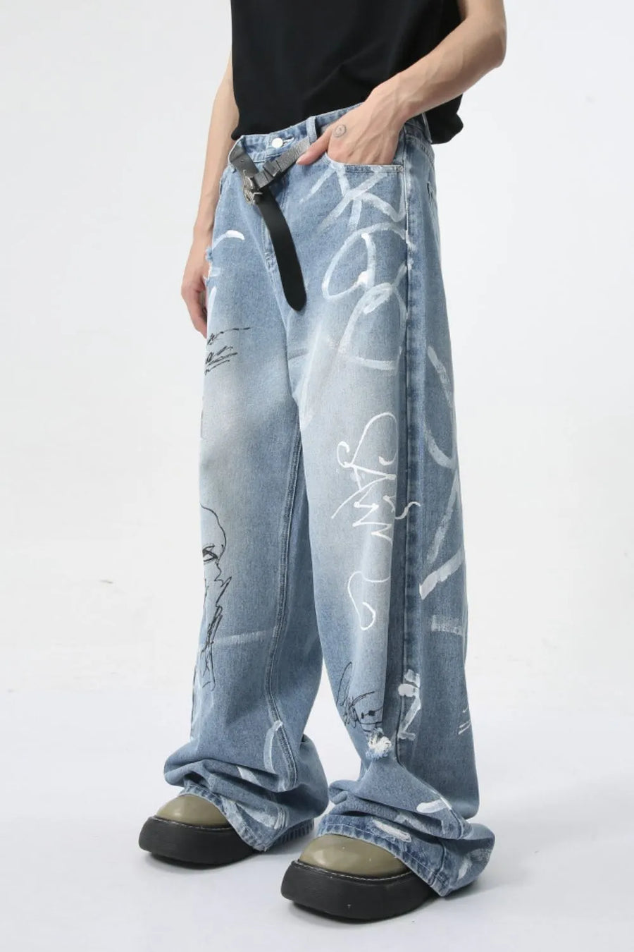 Oversized denim trousers in medium wash with graffiti art print and distressed details.