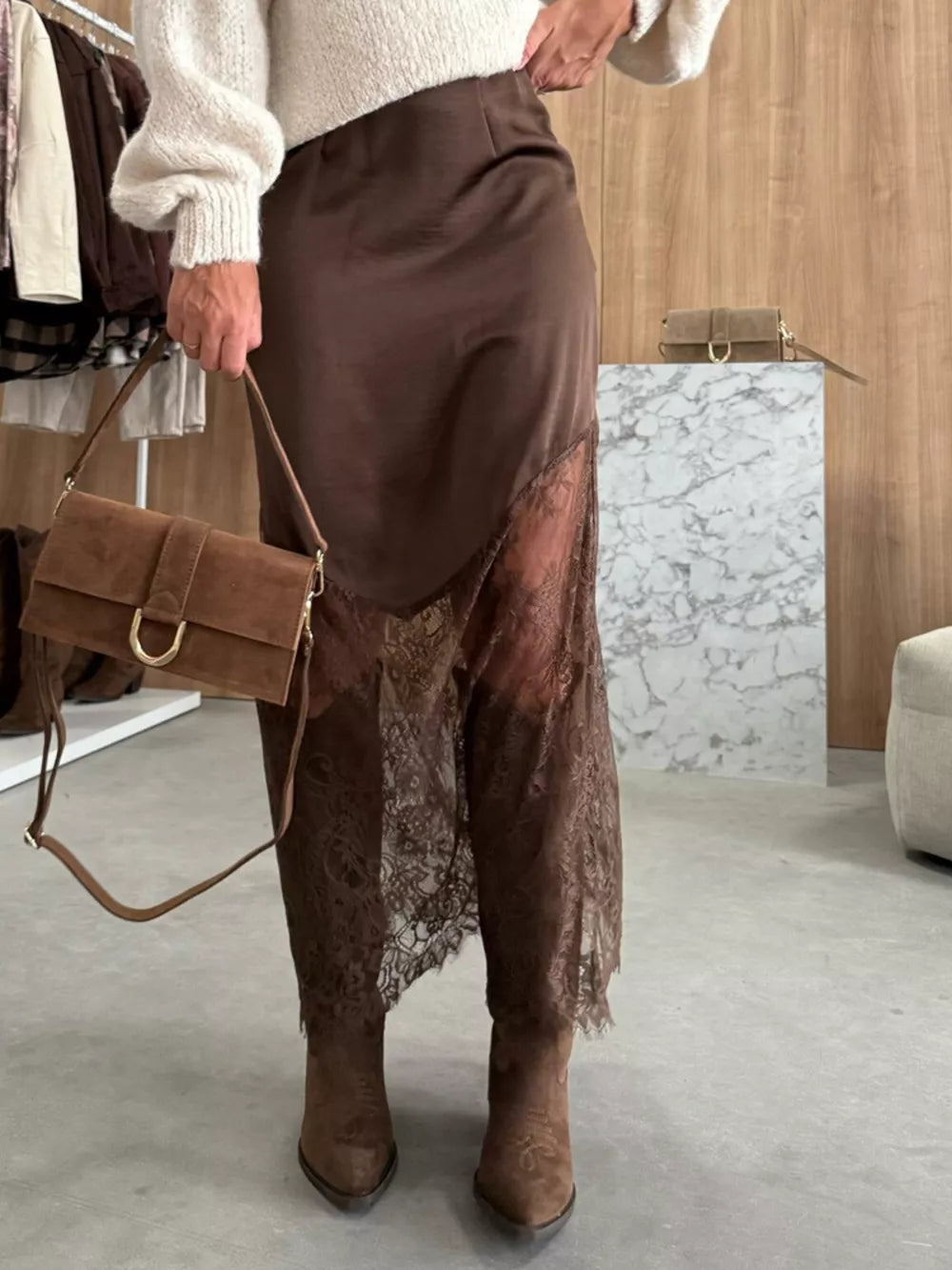 Brown lace trim midi skirt with a satin finish and asymmetrical hem.