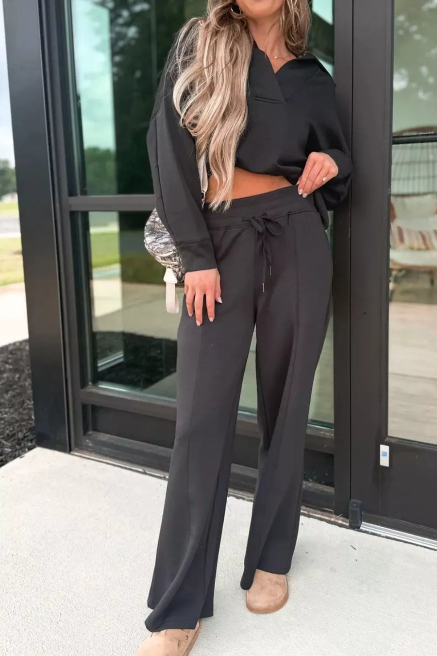 Black collared V-neck sweatshirt and drawstring pants set with a relaxed fit.