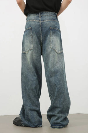 Distressed denim wide leg jeans for men in medium wash, featuring a relaxed fit and vintage wash.