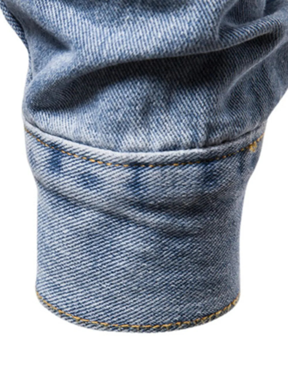 Medium wash denim trucker jacket cuff with visible stitching and classic fit.