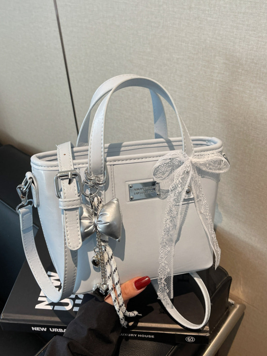 crossbody bag in light gray featuring top handles and boxy fit
