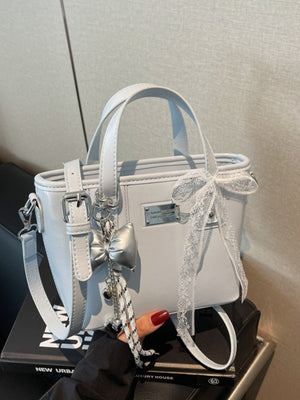 crossbody bag in light gray featuring top handles and boxy fit