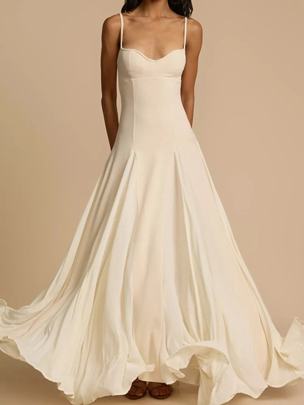 Elegant ivory sweetheart neck maxi dress with flowing skirt and spaghetti straps.