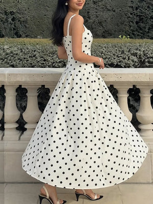 White polka dot A-line maxi dress with a sweetheart neckline and spaghetti straps.