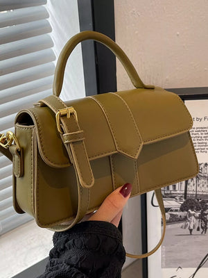 Chic small top handle bag in green with gold buckle detail and a crossbody strap.