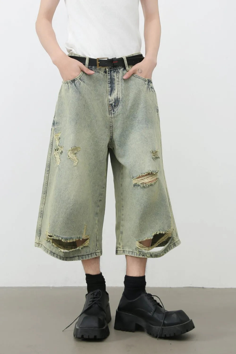Distressed culotte denim shorts in medium wash with ripped details and a wide leg.