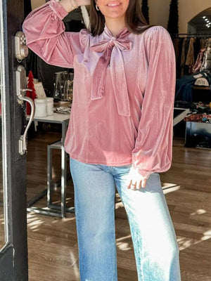 Dusty pink velvet blouse with tie-neck and puff sleeves, styled with jeans.